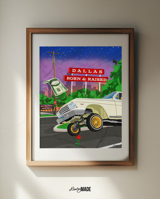A frame on a wall holding a print of The Dallas Concrete Rose artwork - a vibrant illustration by Dre Dooley of a classic 1964 Chevy Impala lowrider with gold wire wheels, hopping in the streets of Dallas. A red street sign reads "Dallas Born & Raised", set against a sunset city skyline. A floating $100 bill, power lines, and urban elements reflect the culture of Dallas, TX. A single red rose grows from a cracked street, symbolizing resilience and roots.