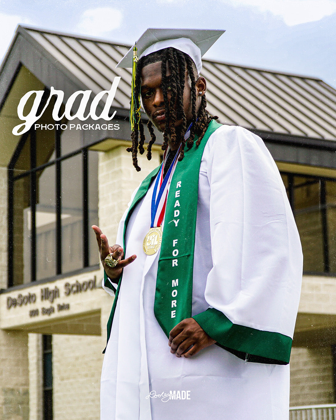 A photo advertising Personalized Graduation Photography and custom digital grad invites. The photo features a graduate in a white cap and gown and green stole standing in front of high school with the sky in the above.