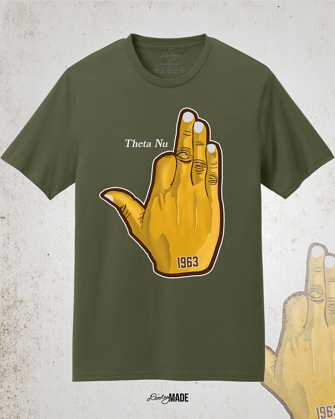 Image showing the front of a customizable Iota Phi Theta shirt with a large gold, brown, and white "Ow-Ow" hand sign with "1963," and the sample custom text "Theta Nu." Shirt is on a textured white background.