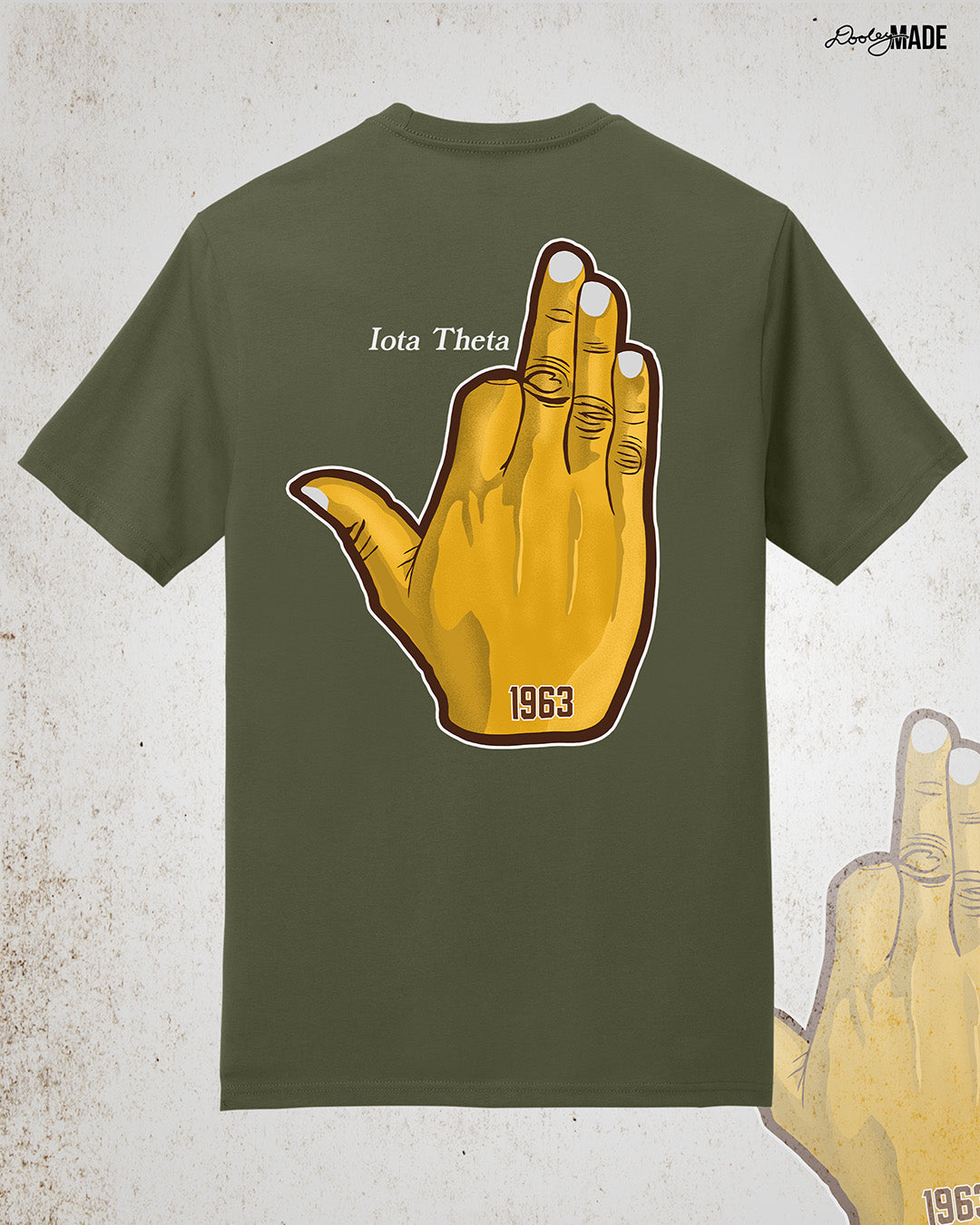 Image showing the back of a customizable Iota Phi Theta shirt with a large gold, brown, and white "Ow-Ow" hand sign with "1963," and the sample custom text "Iota Theta." Shirt is on a textured white background.
