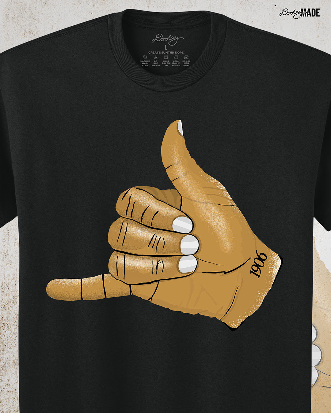 Black t-shirt with an old gold Alpha Phi Alpha Fraternity, Inc. "ICE" hand sign with "1906" text on the wrist. Zoomed in on shirt to show some of the detail.