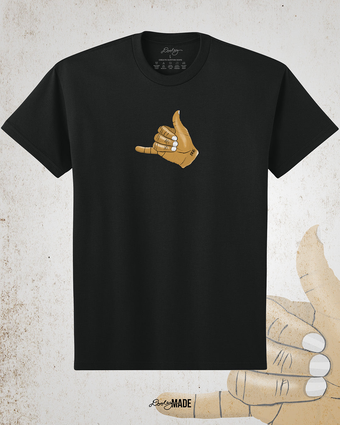 The front of a Black t-shirt with an old gold Alpha Phi Alpha Fraternity, Inc. "ICE" hand sign with "1906" text on the wrist. Image shows the design small on middle of the chest on the front of the shirt.