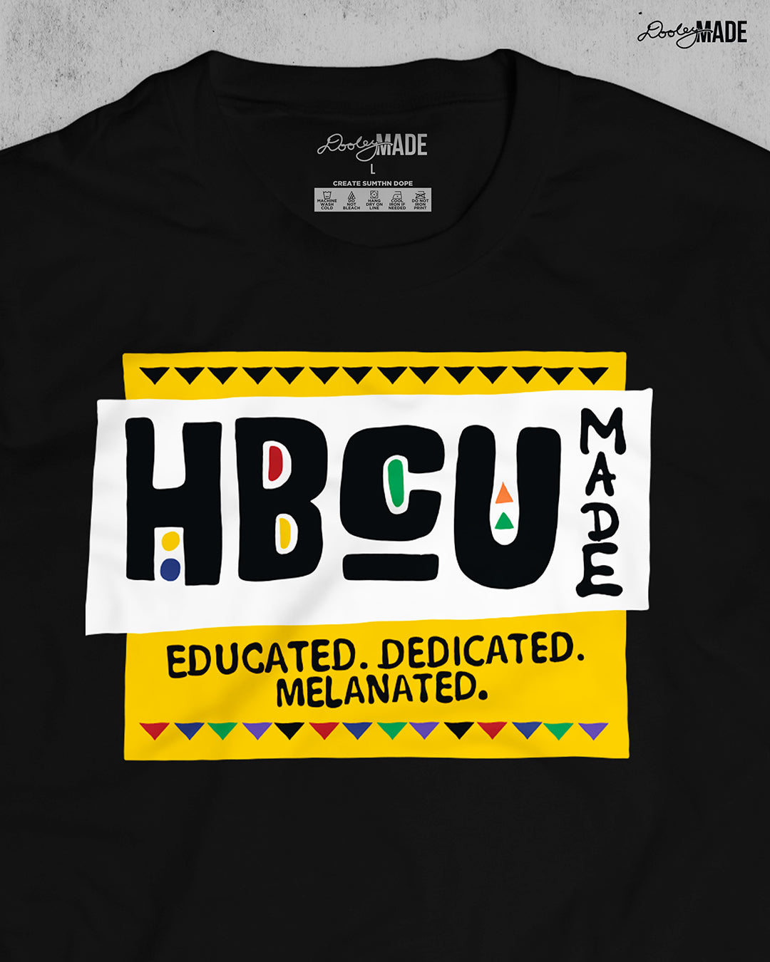 A premium black shirt featuring a bold HBCU Made 90s Martin Show themed design featuring the text "Educated, Dedicated, Melanated. The design is white, black, yellow, and various other vibrant colors.