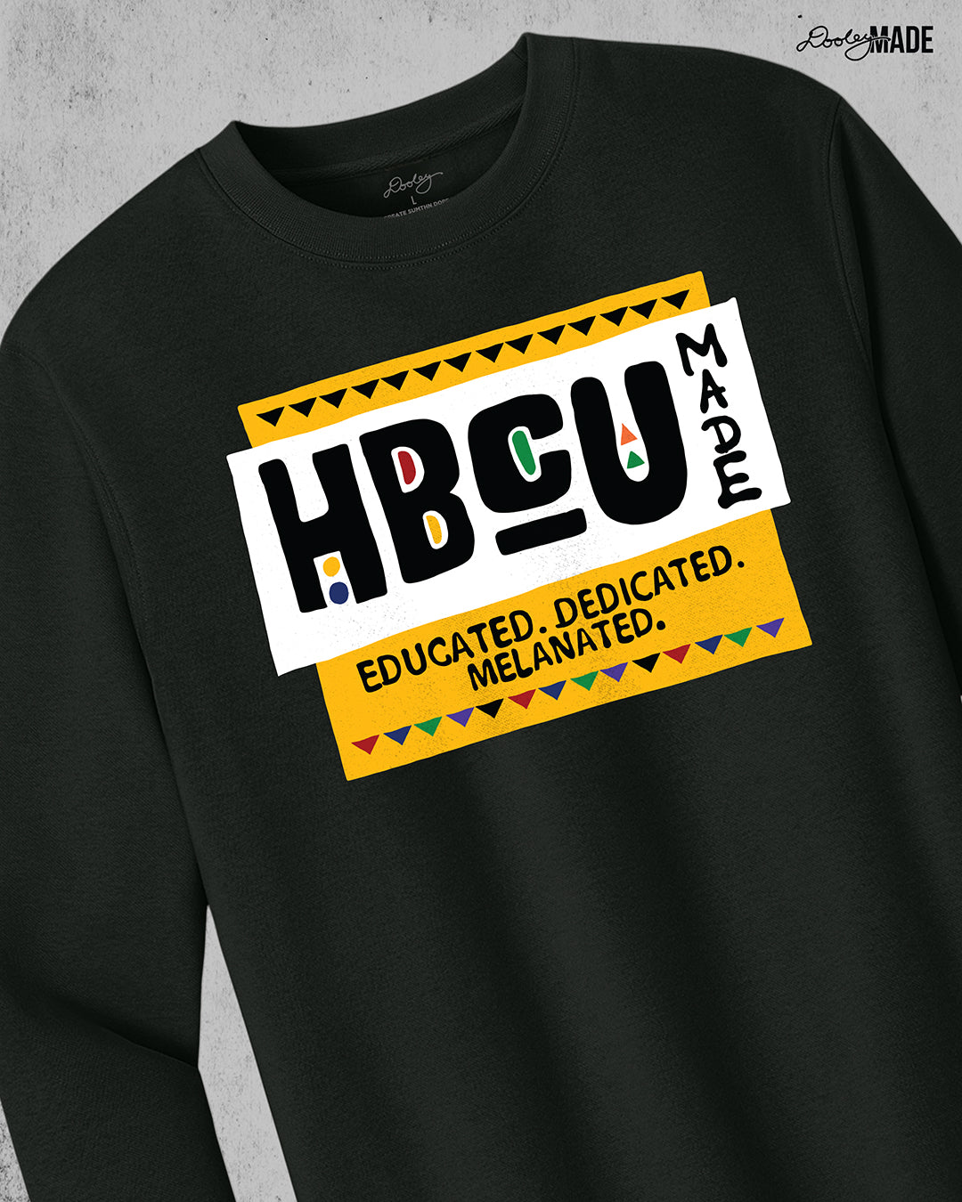 A premium black crewneck sweater featuring a bold HBCU Made 90s Martin Show themed design featuring the text "Educated, Dedicated, Melanated. The design is white, black, yellow, and various other vibrant colors.
