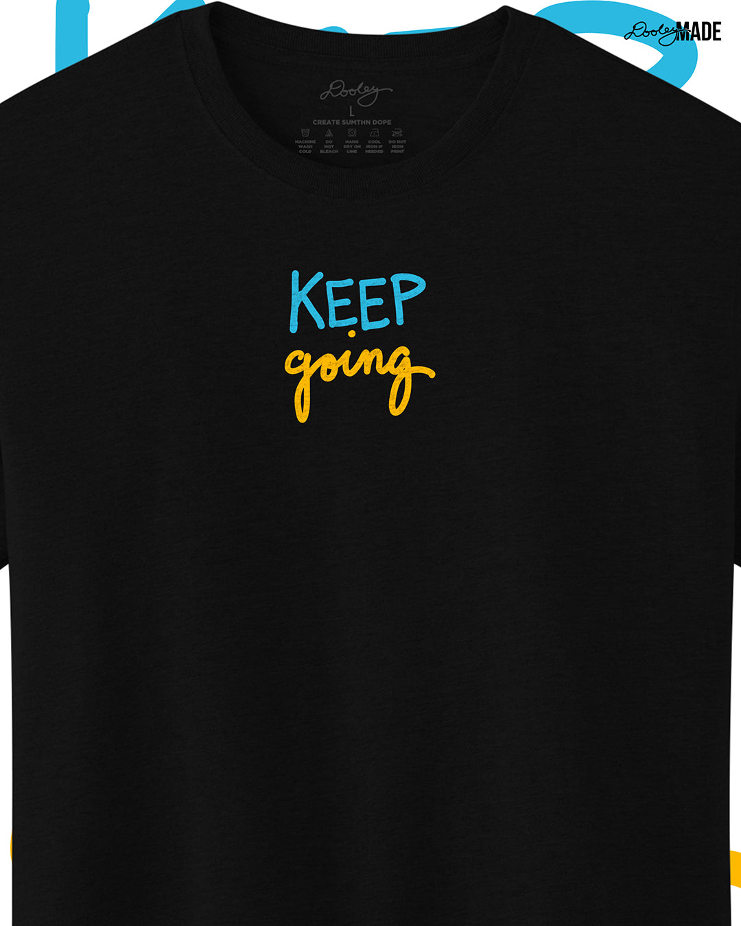 Heavyweight Black t-shirt with 'KEEP going' text in blue and yellow on a white background, slightly zoomed to show detail.