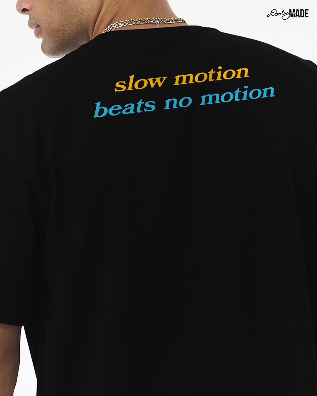 Heavyweight Black t-shirt with 'slow motion beats no motion' text on the back, worn by a person.