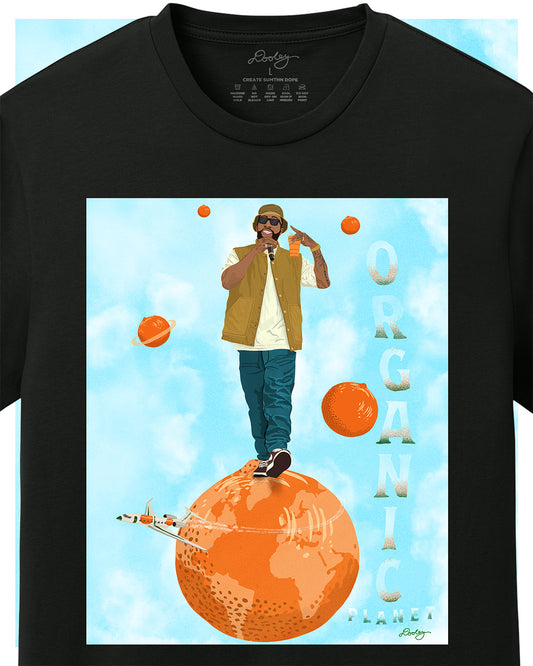 A black Larry June themed graphic t-shirt featuring a Larry June illustration of him standing on an orange planet with smaller floating orange planets, alongside the text "Organic Planet." Bold casual wear design blending creativity, luxury, and hip-hop culture. Zoomed to show detail.
