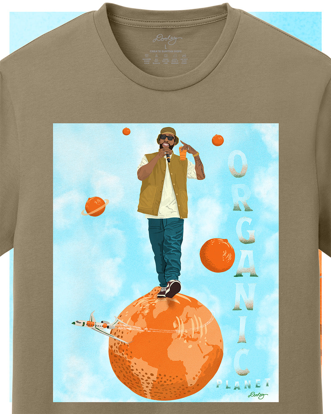 A khaki tan Larry June themed graphic t-shirt featuring a Larry June illustration of him standing on an orange planet with floating orange planets, alongside the text "Organic Planet." Bold casual wear design blending creativity, luxury, and hip-hop culture. Zoomed to show detail.