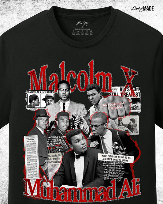 The front of a Black t-shirt featuring a collage of Malcolm X and Muhammad Ali with newspaper headlines and photos, titled 'Malcolm X & Ali: Blood Brothers' in bold red and white text. Zoomed to show detail.