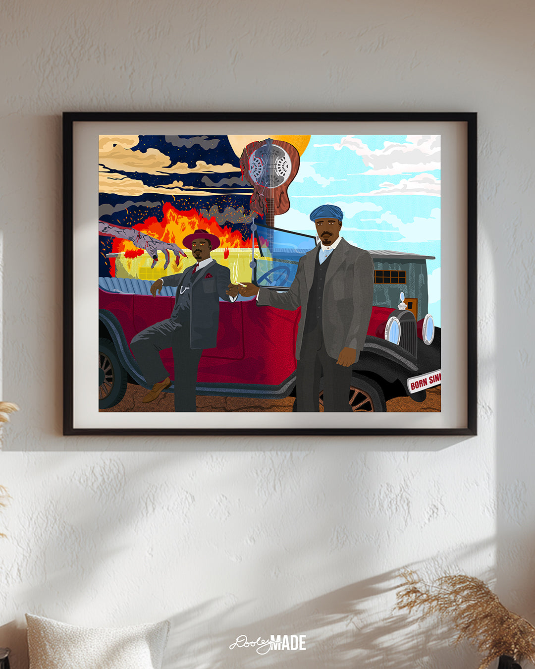 A framed and centered Illustration of Michael B. Jordan as The Smoke Stack Twins in the Sinners movie, showing them stand together in front of a vintage red car sharing a cigarette. Sammy’s split guitar divides night and day with one side of a building burning and the other side untouched in the background. A bloody, lifeless hand extends toward Stack as his eyes glow red. Wall art is on a textured white wall with decorative elements around it.