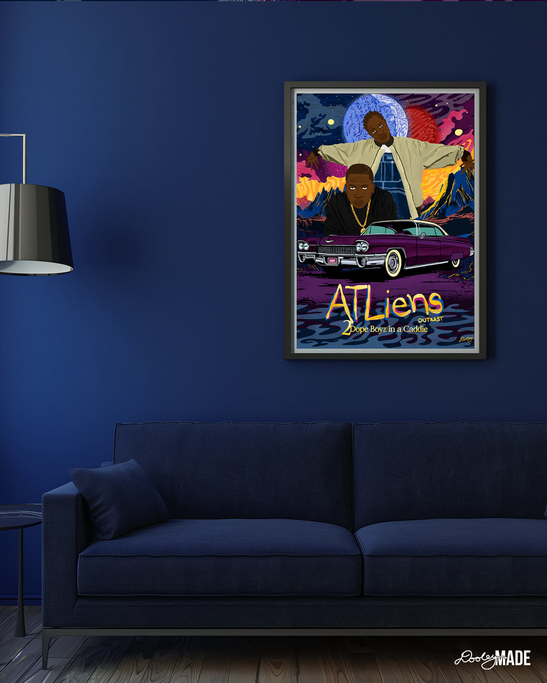 A custom OutKast illustration featuring an out of this world theme and an old school Cadillac, capturing the essence and colorful complexity of OutKast's extra-terrestrial rhymes. The artwork sits in a black frame in a navy blue room above a navy blue modern couch next to a lamp.