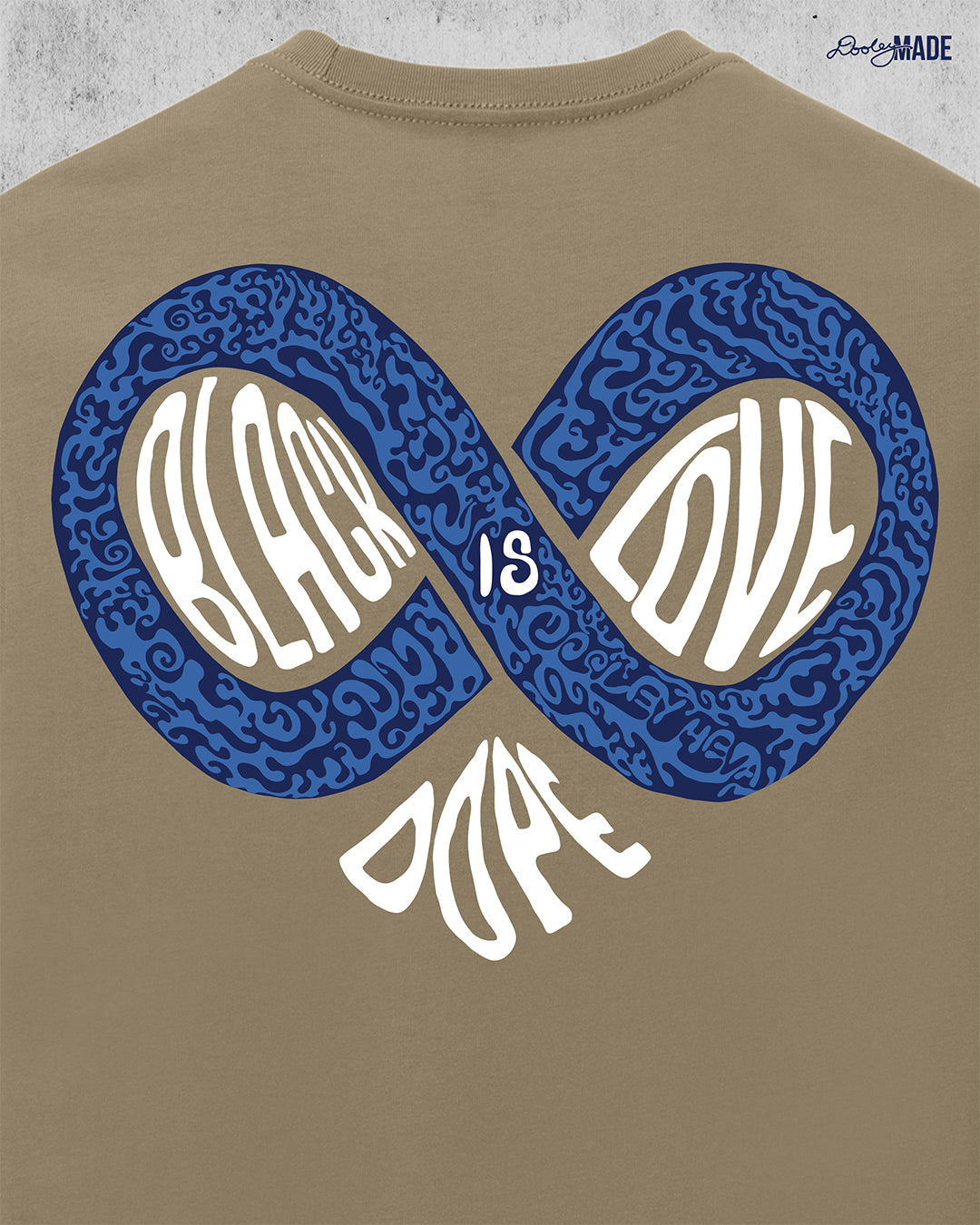 An image of the back of a desert tan colored shirt reading "Black Love is Dope" featuring an infinity symbol that combines with the word "Dope" to make the shape of a heart.  