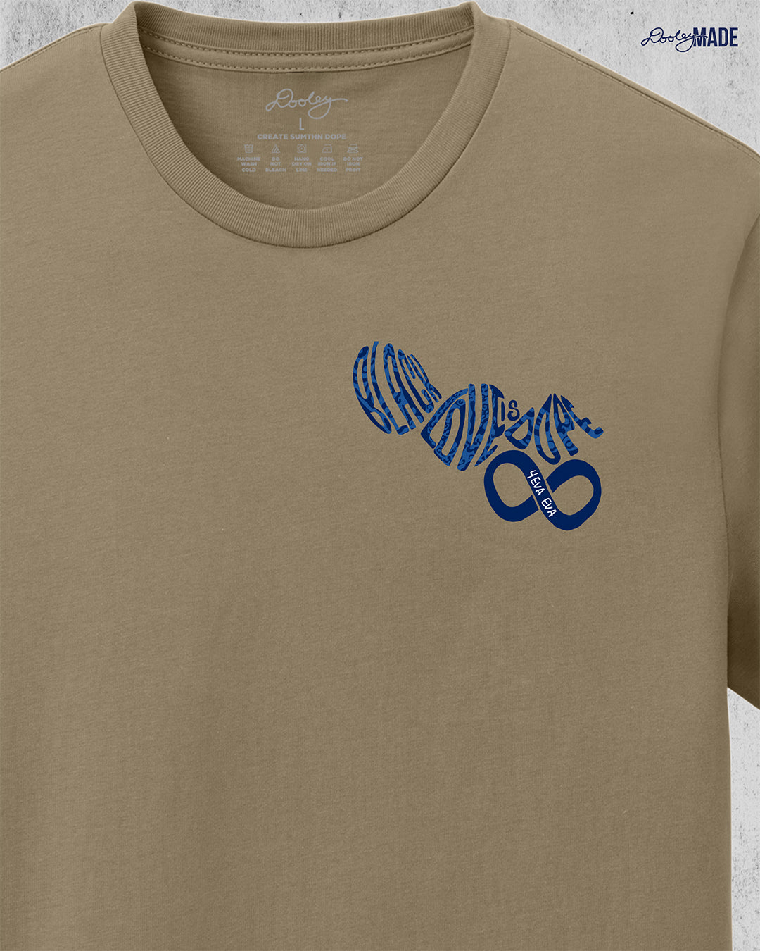 An image of the front of a desert tan colored shirt reading "Black Love is Dope" with an infinity symbol on the left chest in navy blue.