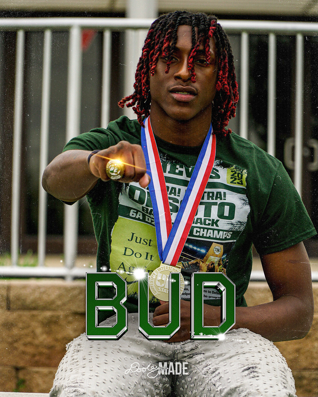 A photo advertising Personalized Graduation Photography showing a graduate with an arm outstretched with a shinning gold championship ring on his hand. A name is shown a graphic in 3D text across the image. 
