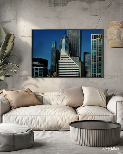 A beautiful picture showcasing a cluster of towering skyscrapers in Chicago, with a vibrant blue sky as a backdrop on the wall in a Boho Chic, tan room. The buildings exhibit a variety of architectural styles, with sleek glass facades and modern designs dominating the skyline.