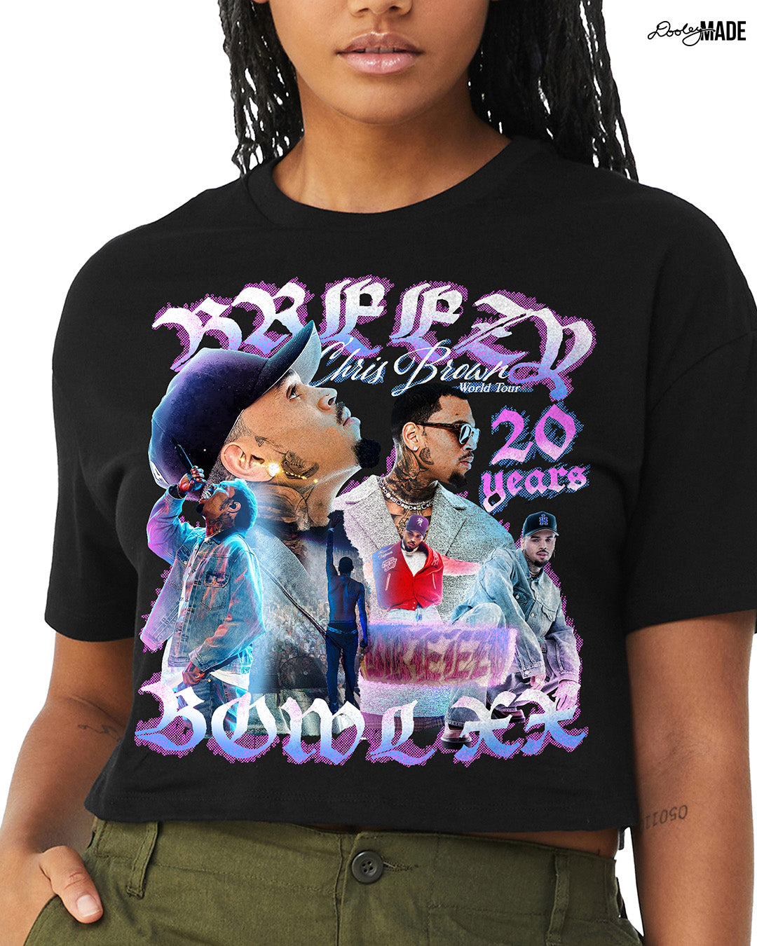 A model wearing a black crop top t-shirt with a pink, blue, and white graphic that says 'Breezy Bowl XX,' 'Chris Brown World Word Tour' and '20 Years.' The graphic also features a collection of stylized Chris Brown photos with pink and blue highlights. 