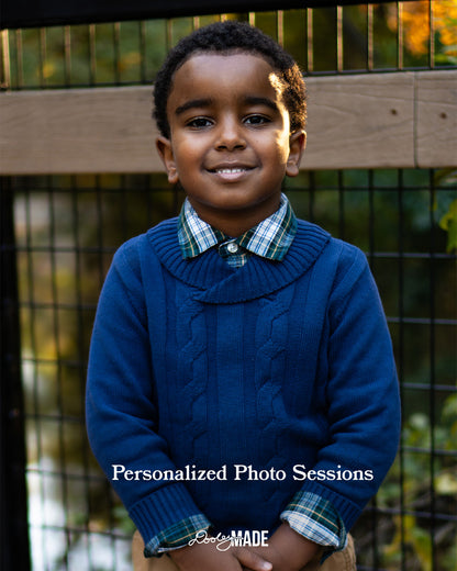 A brown skinned child wearing a blue sweater with a plaid shirt underneath, standing outdoors, advertising Personalized Photo Sessions in the Dallas DFW Metroplex by Dooley Made.