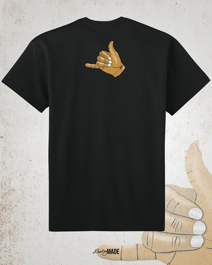 The back of a Black t-shirt with an old gold Alpha Phi Alpha Fraternity, Inc. "ICE" hand sign with "1906" text on the wrist. Image shows the design small on the upper portion of the back. 