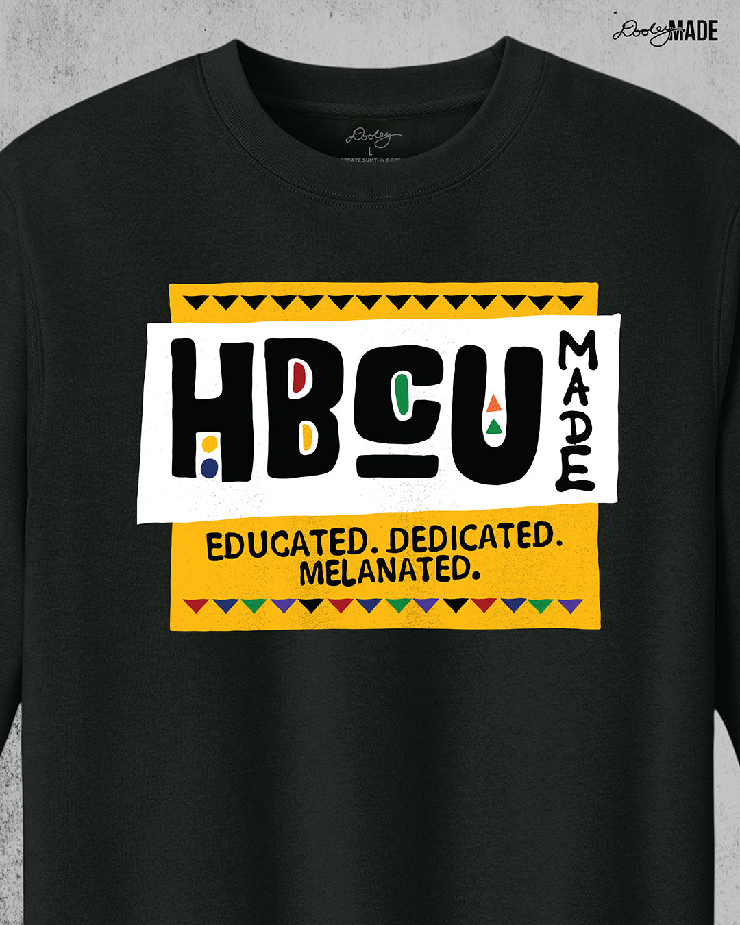 A premium black crewneck sweater featuring a bold HBCU Made 90s Martin Show themed design featuring the text "Educated, Dedicated, Melanated. The design is white, black, yellow, and various other vibrant colors.