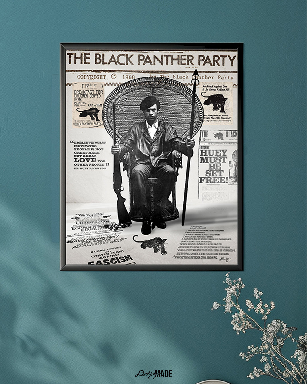 An image of framed Huey P. Newton artwork featuring the Black Panther Party's 10 Point Program, a poster that hung inside the door of the Chicago Chapter headquarters, the quote "I believe what motivates people is not great hate, but great love for other people," and other historical memorabilia. The frame is on the blue-teal wall in a living room setting.