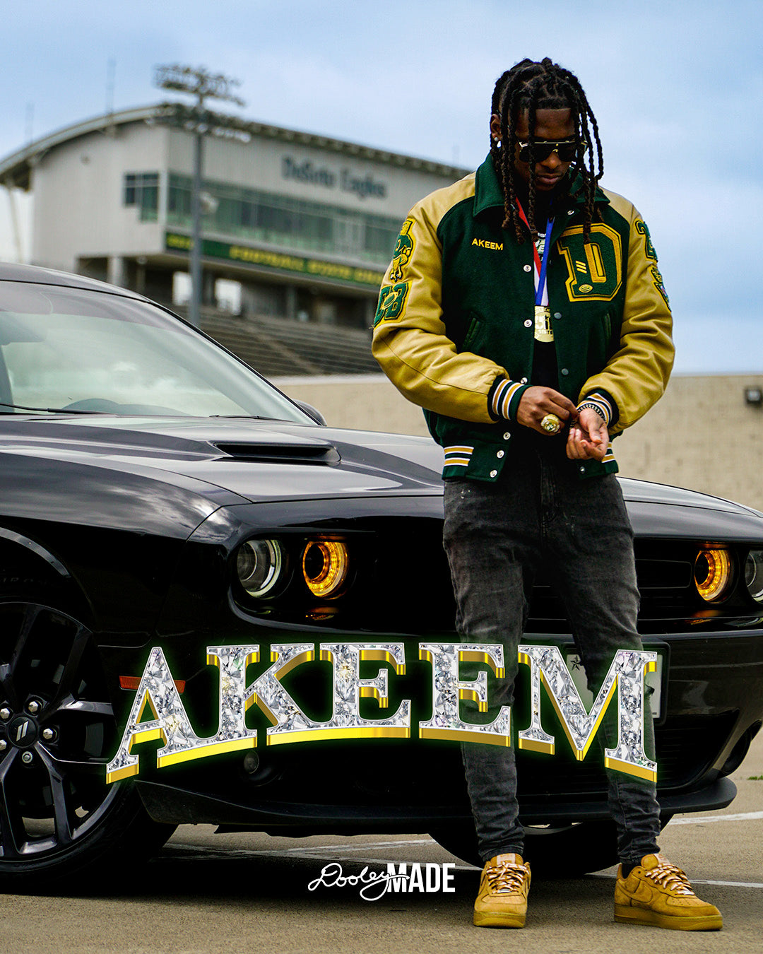A photo advertising Personalized Graduation Photography showing a graduate standing in front of a care wearing a green letterman jacket and state UIL medal. A graphic of a name is featured prominently across the image. The background show a towering football stadium. 