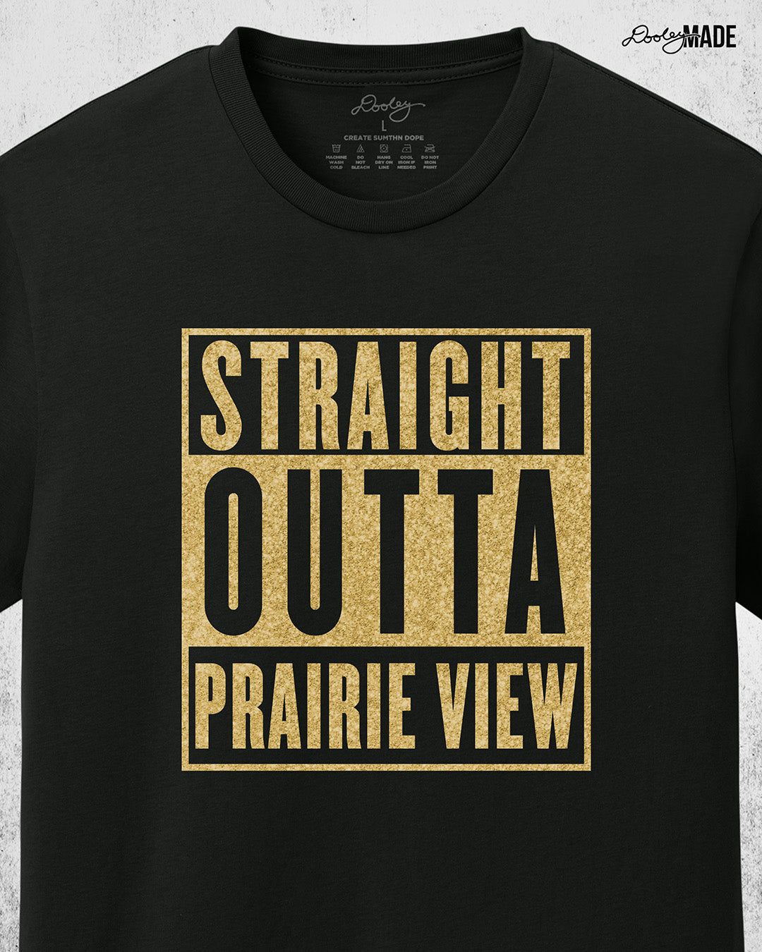 A black Prairie View A&M University Shirt with "Straight Outta Prairie View" in a shinny golden design across the chest. Perfect for alumni, students, and gradates that want to celebrate their HBCU pride with a shine. Zoomed to show detail. 