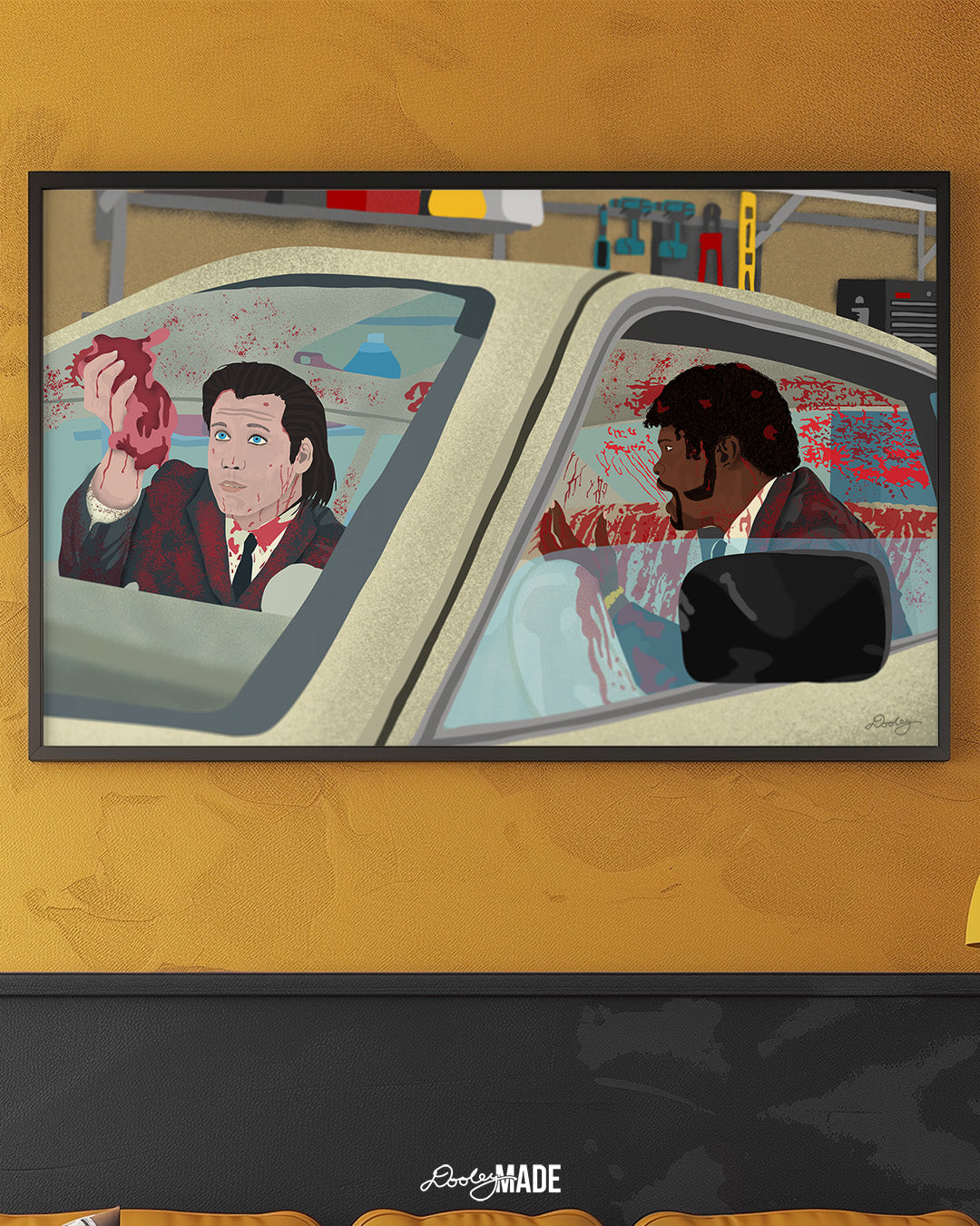 An image showing a framed photo of a stylized illustration by Dre Dooley titled "The Accident" depicting a scene from the movie Pulp Fiction on yellow/gold wall in a room. Covered in blood, Samuel L. Jackson and John Travolta argue while cleaning blood and brain from a car's interior as it sits in a garage. 