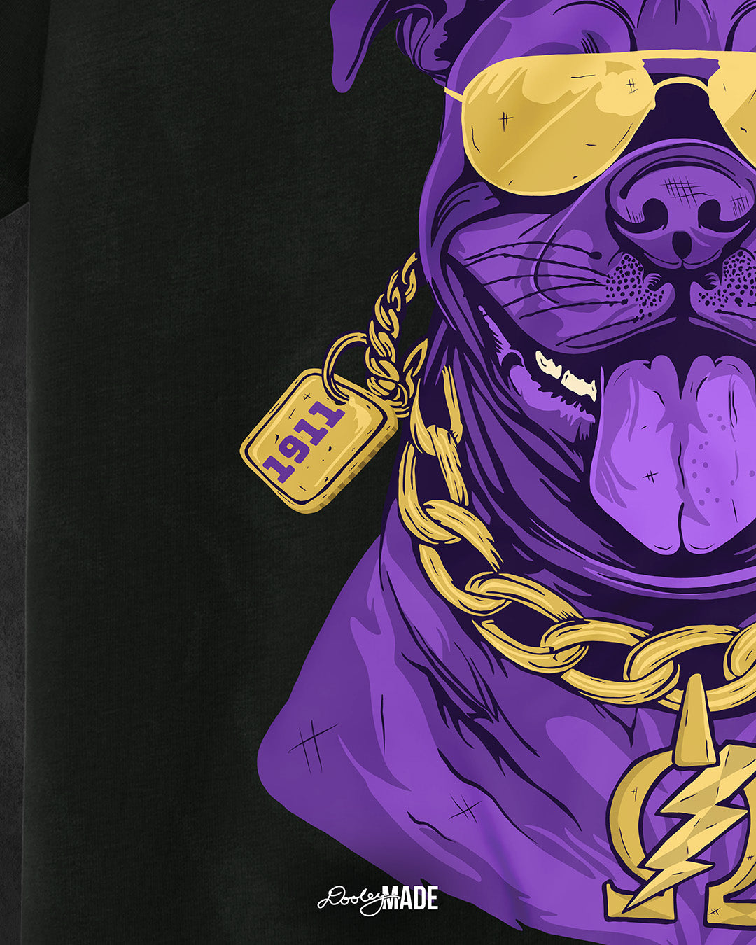 A zoomed in photo of the left side a black shirt with a graphic of an Omega Psi Phi Fraternity, Inc themed Pit Bull Dog wearing gold aviator sunglasses and a gold Omega Psi Phi necklace.