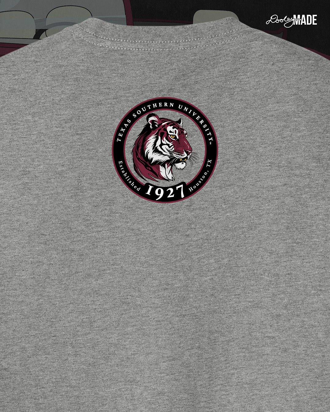 An image of the back of a heather gray Texas Southern University graphic tee shirt featuring a 3rd Ward University design and a maroon old school car with elbow rims. There is also a Scott St and Wheeler Ave street sign with a stop sign with the Texas Southern University logo on it. The back shows a circular print with the words Texas Southern University Established 1927 Houston, Tx  around the border with a stylized tiger inside of it. 