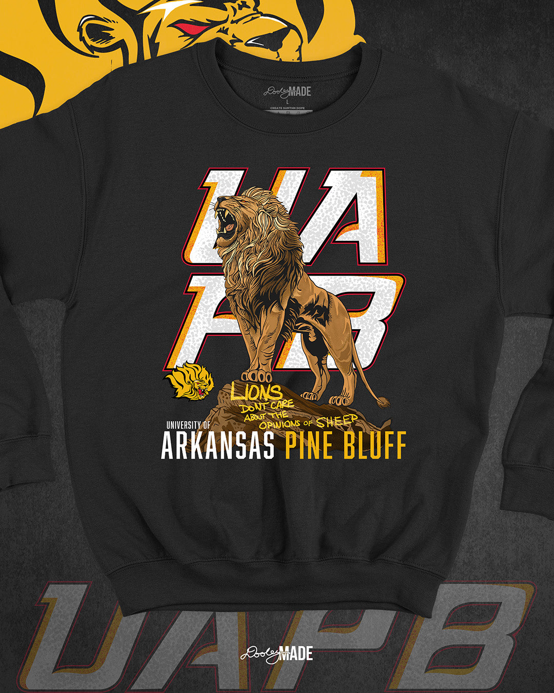 The front of a black University of Arkansas Pine Bluff graphic crewneck sweater with the slogan "Lions Don't Care About The Opinions of Sheep" on the front with a Lion roaring on top of a rock in front of a stylized UAPB logo.