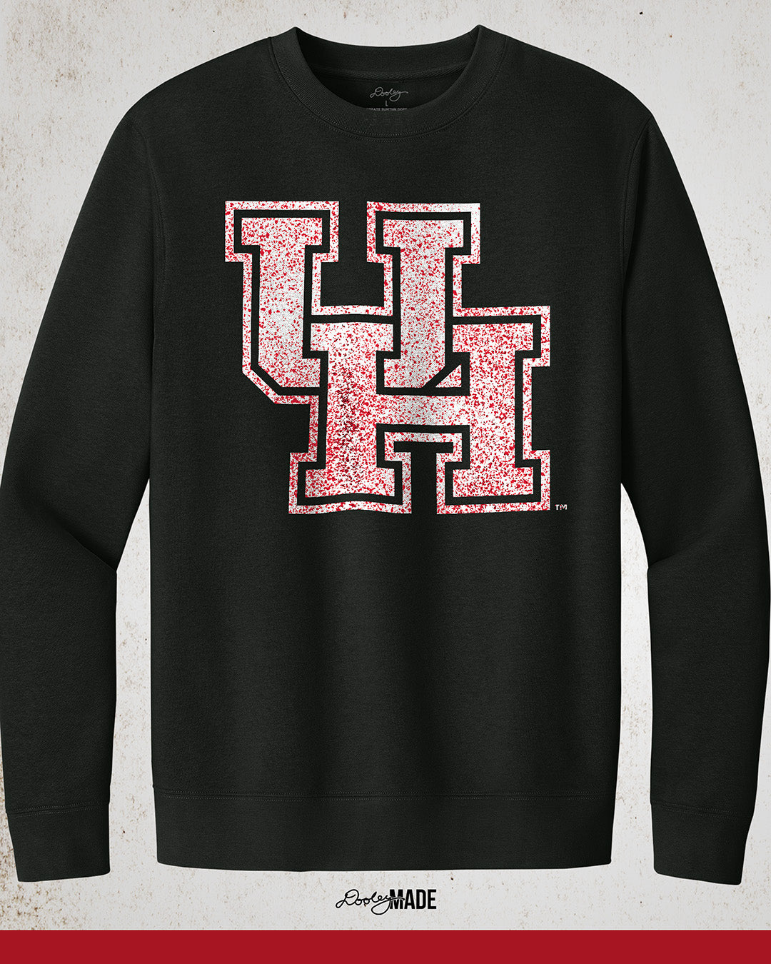 Image showing a black University of Houston crewneck sweatshirt with a white UH logo with red speckles stretched across the front.