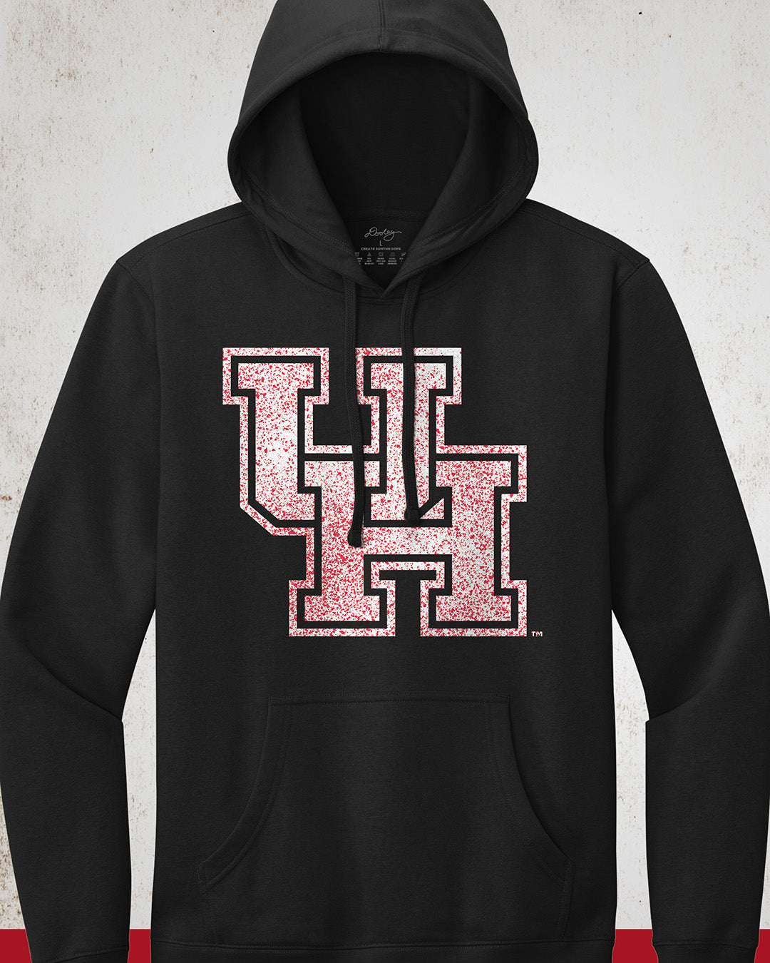Image showing a black University of Houston hoodie with a white UH logo with red speckles stretched across the front.