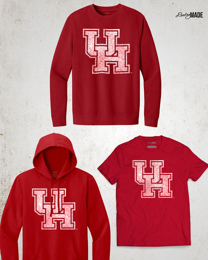 Image showing a red University of Houston crewneck sweatshirt, hoodie, and shirt with a shirt UH logo with red speckles. 