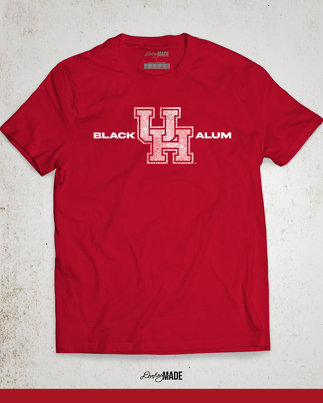 Image of a red "Black UH Alumni shirt" showcasing bold, white text reading "BLACK ALUM" flanking a speckled white and red "UH" logo in the center. The design emphasizes pride and unity for Black alumni of the University of Houston, presented on a stylish and modern garment ideal for representing school spirit and Cougar pride.