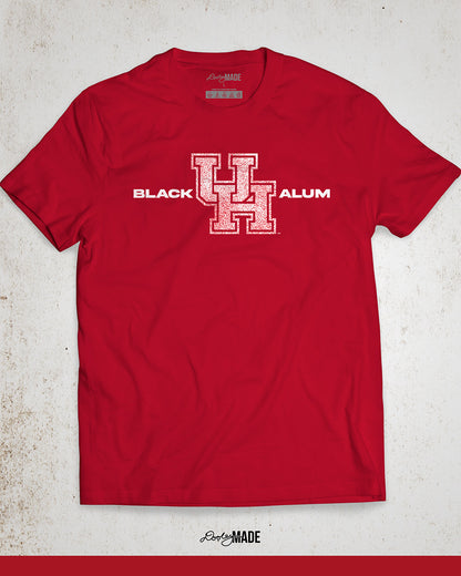 Image of a red "Black UH Alumni shirt" showcasing bold, white text reading "BLACK ALUM" flanking a speckled white and red "UH" logo in the center. The design emphasizes pride and unity for Black alumni of the University of Houston, presented on a stylish and modern garment ideal for representing school spirit and Cougar pride.