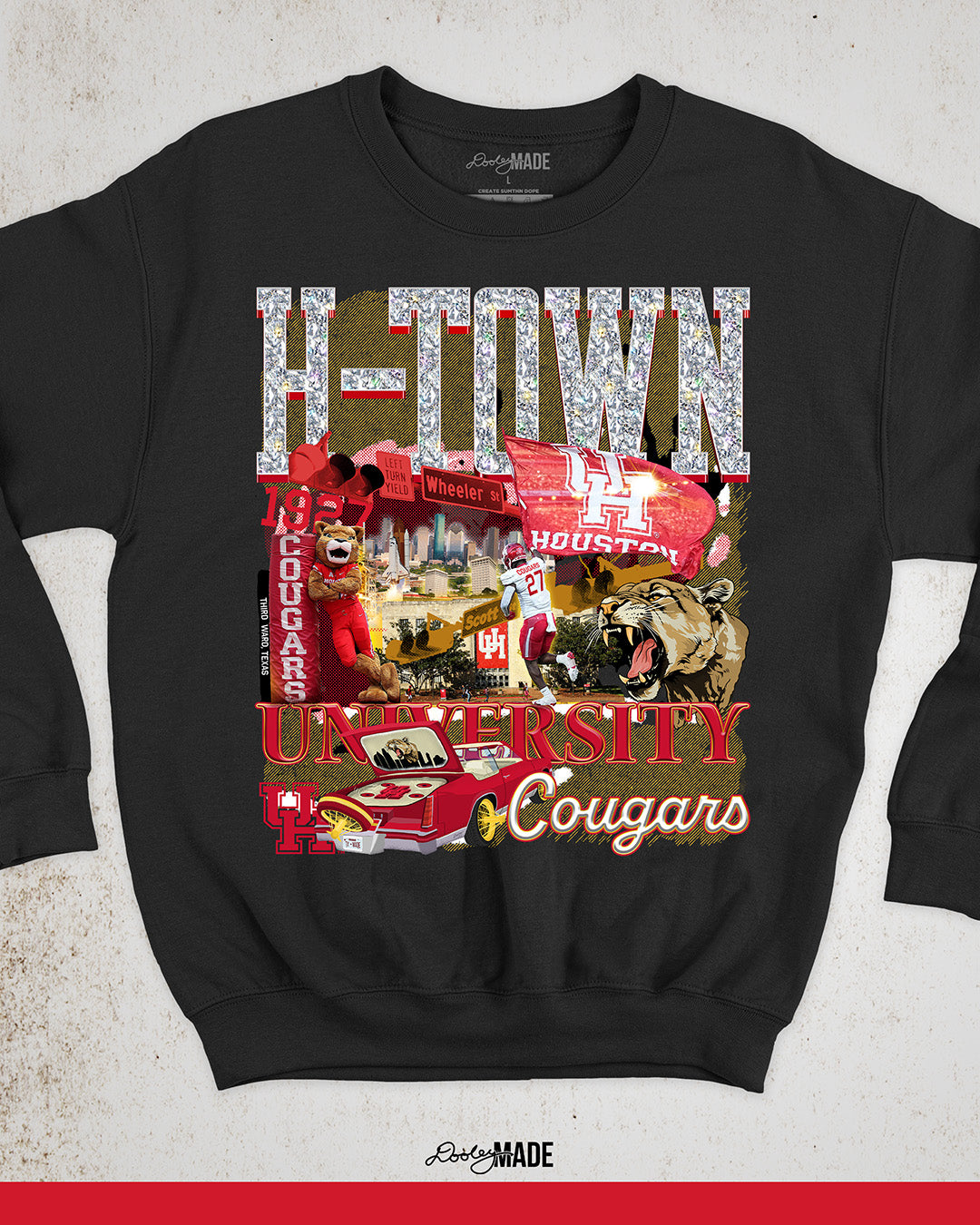 A black University of Houston themed crewneck sweater featuring a vibrant HTOWN University graphic collage with "H-TOWN" text in diamonds, Cougar mascot, players, city skyline, and classic lowrider in a vibrant collage design.