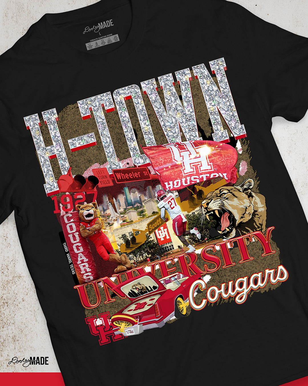 A black University of Houston themed shirt featuring a vibrant HTOWN University graphic collage with "H-TOWN" text in diamonds, Cougar mascot, players, city skyline, and classic lowrider in a vibrant collage design.