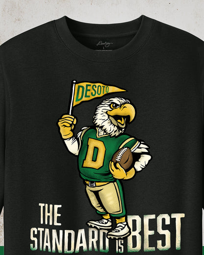  Vintage black crewneck sweatshirt featuring a retro-inspired eagle mascot holding a football and waving a "DeSoto" Pennant flag. Bold text reads "The Standard is Best," accented with green and gold colors, celebrating DeSoto High School pride and tradition.